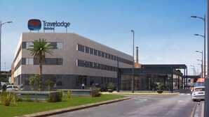 A modern building with a Travelodge sign, featuring a flat roof, large windows, and a covered entrance. - Travelodge Valencia Aeropuerto (Manises)