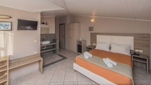Una habitación de hotel con cama, mesita de noche y baño con lavabo y espejo.