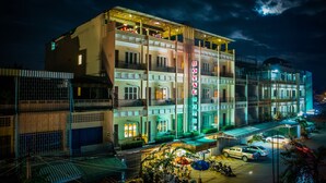 A multi-story hotel with balconies and a neon sign reading "ROYAL HOTEL". - Royal Hotel (Battambang)