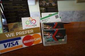 Una mesa con varias tarjetas de pago y folletos de hotel.