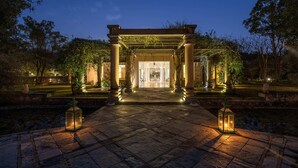 A stone pathway leading to a covered entrance with columns and lanterns, surrounded by greenery. - The Tree of Life Resort & Spa, Jaipur (Amer)