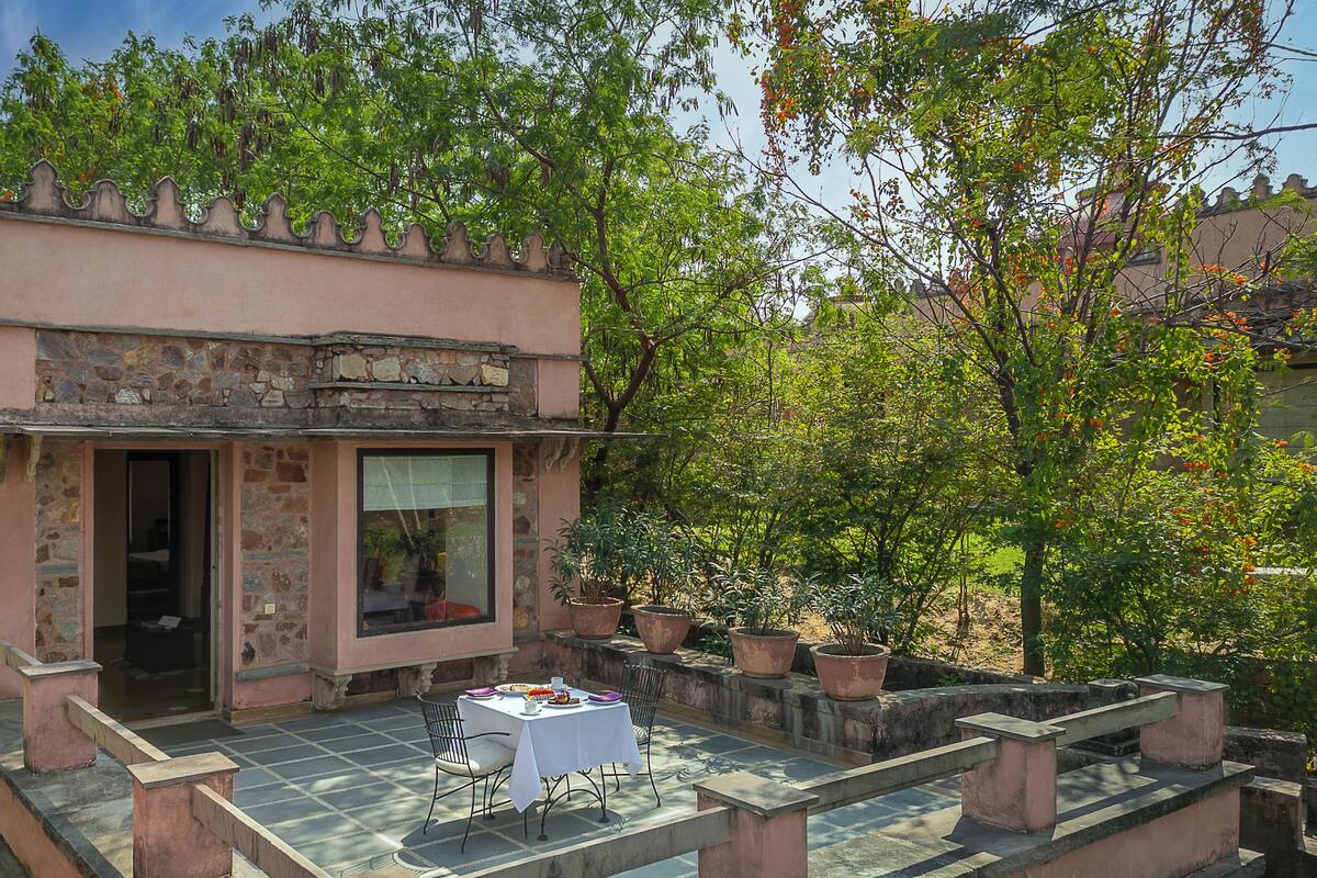 A small, stone building with a balcony and a table set for dining.
