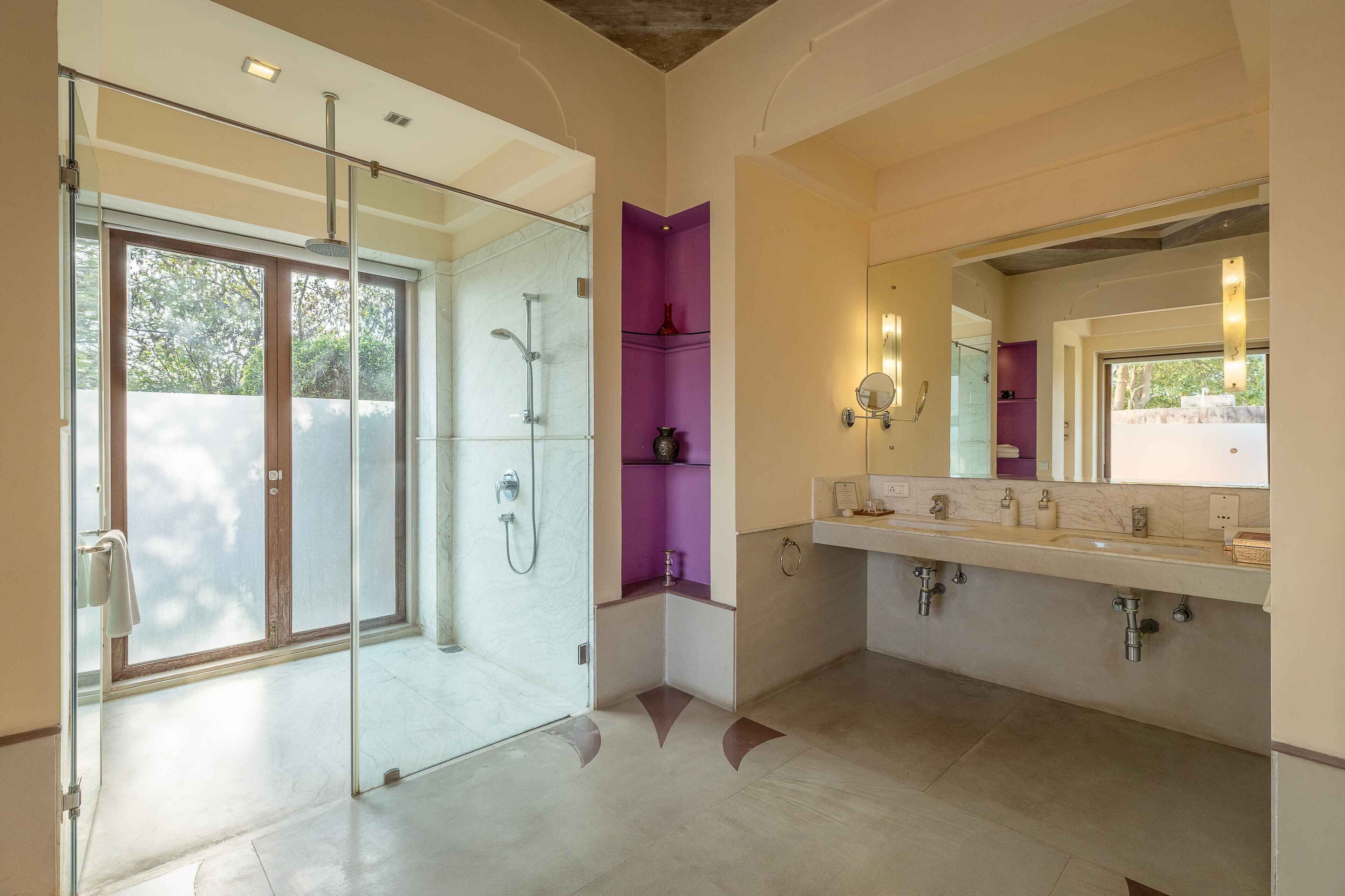A modern bathroom with a glass-enclosed shower, a vanity with dual sinks, and a large mirror.
