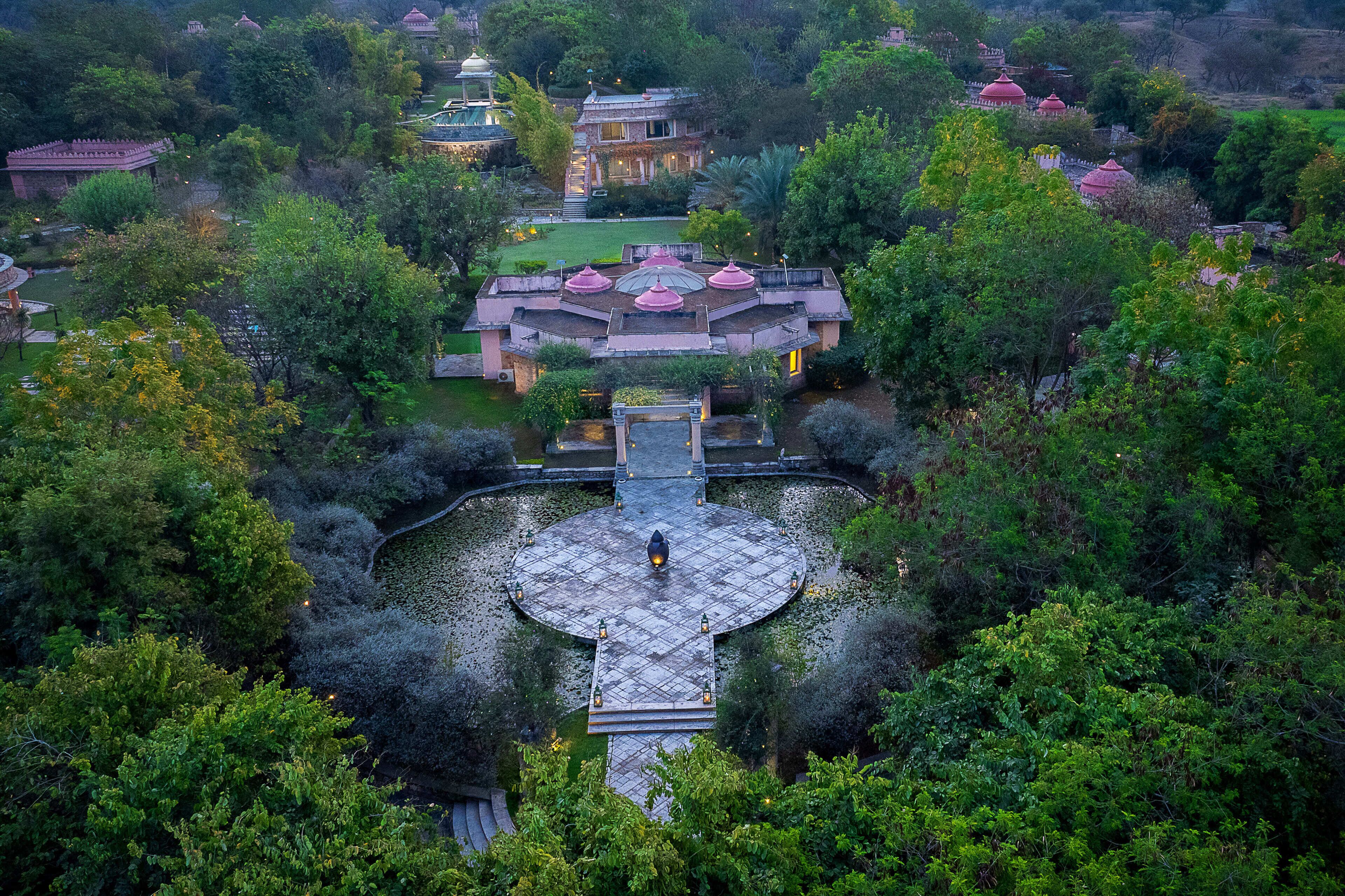 An aerial view of a traditional building with a central courtyard surrounded by lush greenery.