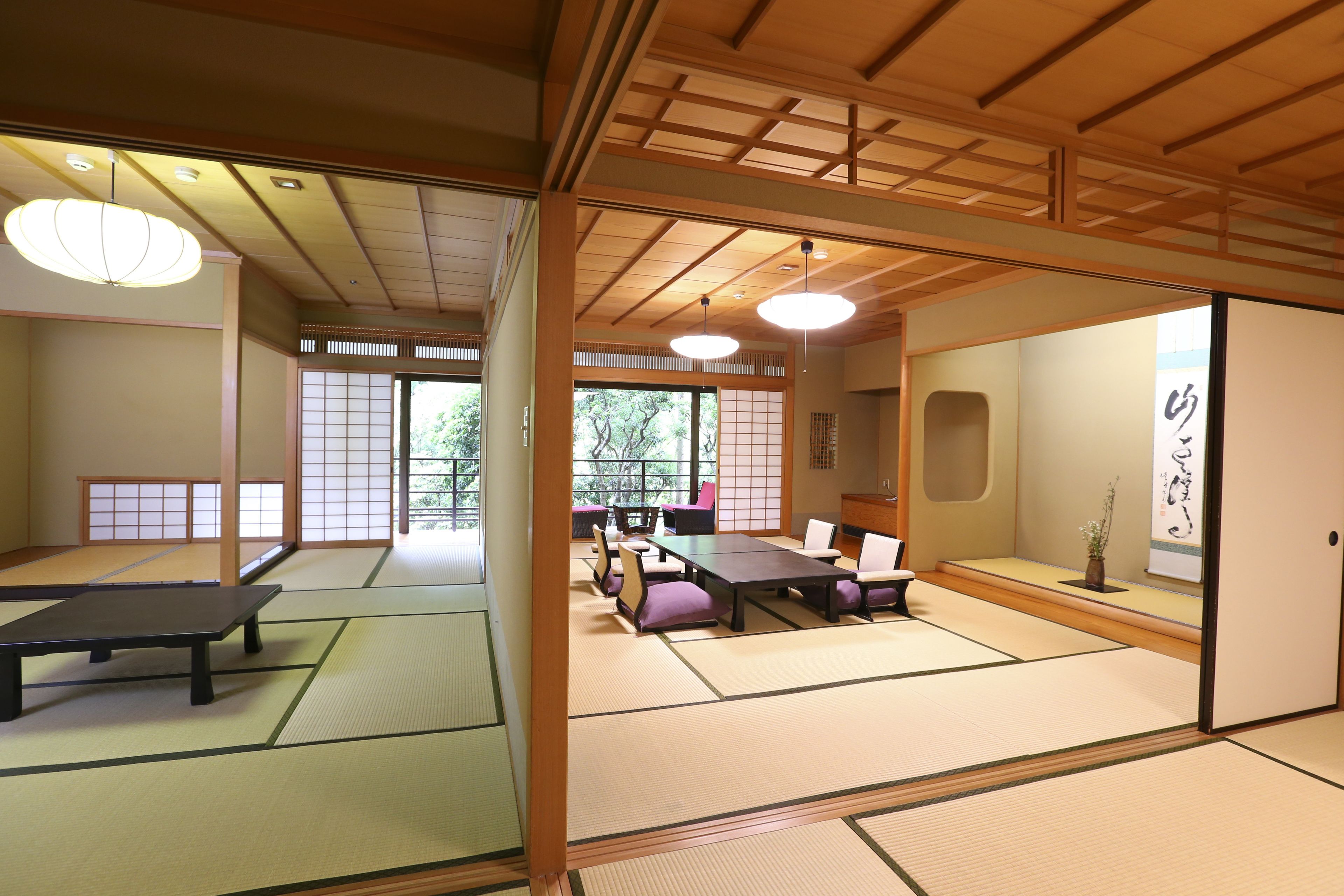A traditional Japanese room with tatami flooring, a low table, and a sliding door.