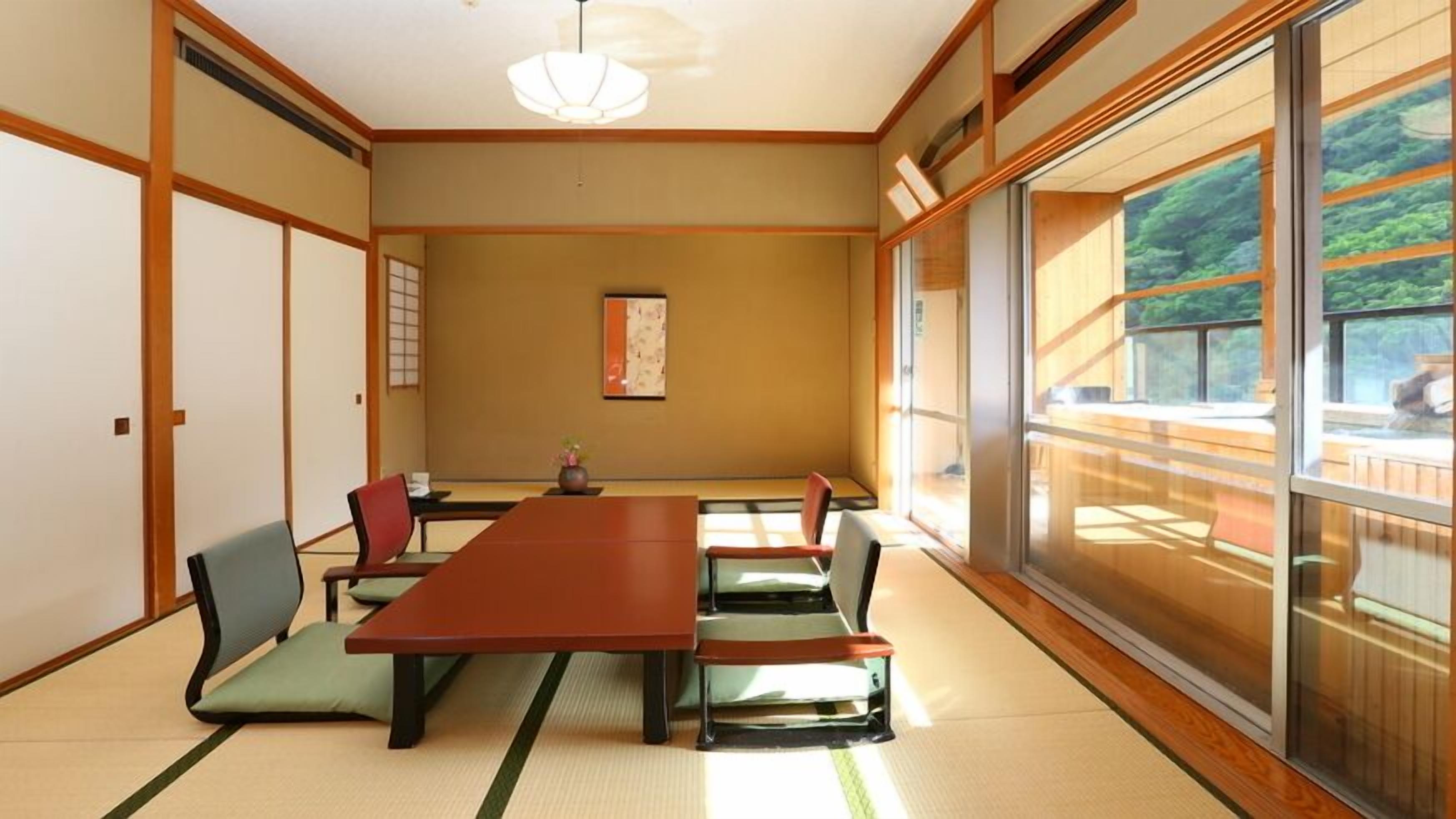 A traditional Japanese-style room with tatami flooring, a low table, and sliding doors.