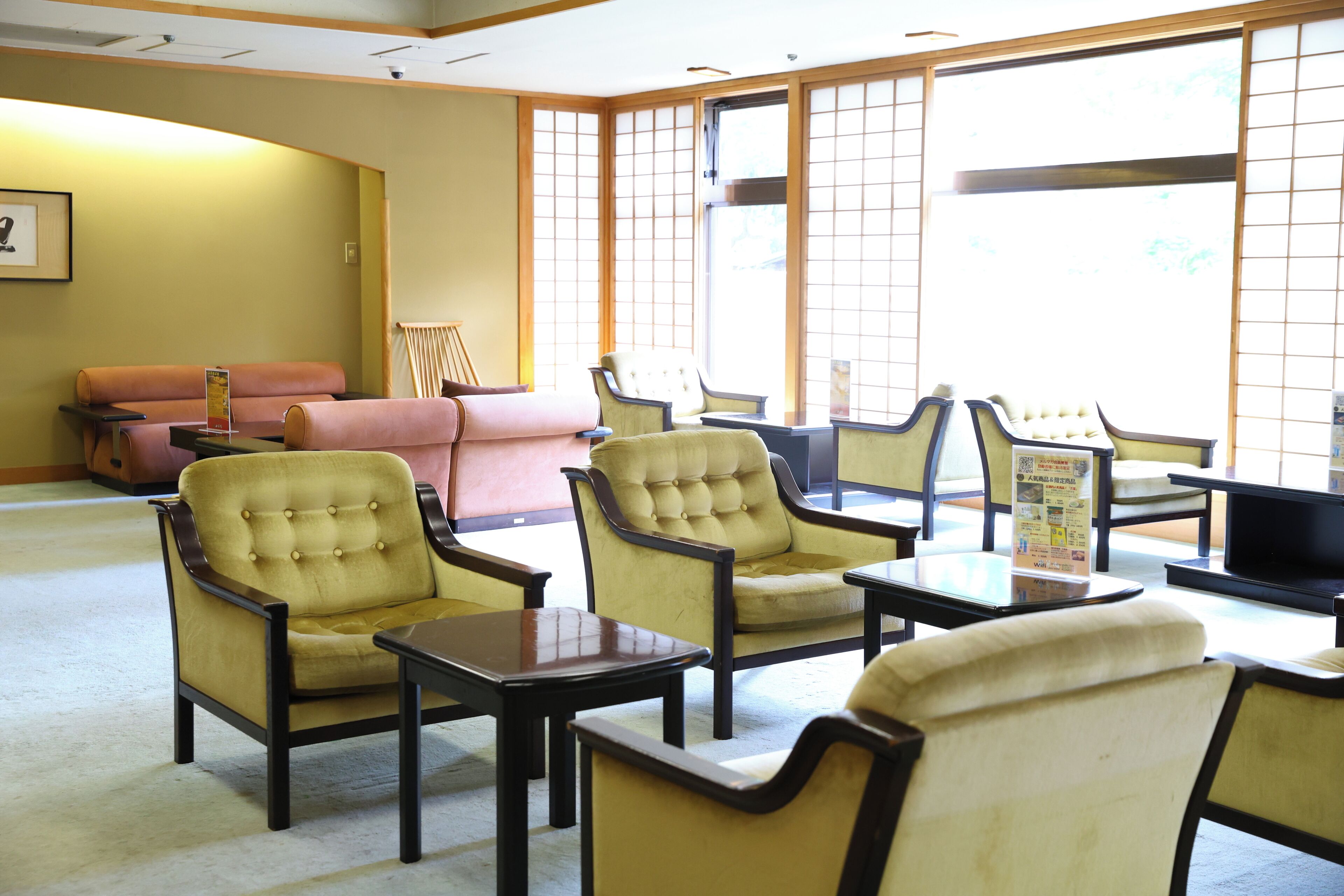 A traditional Japanese-style room with tatami flooring, low tables, and cushioned seating.