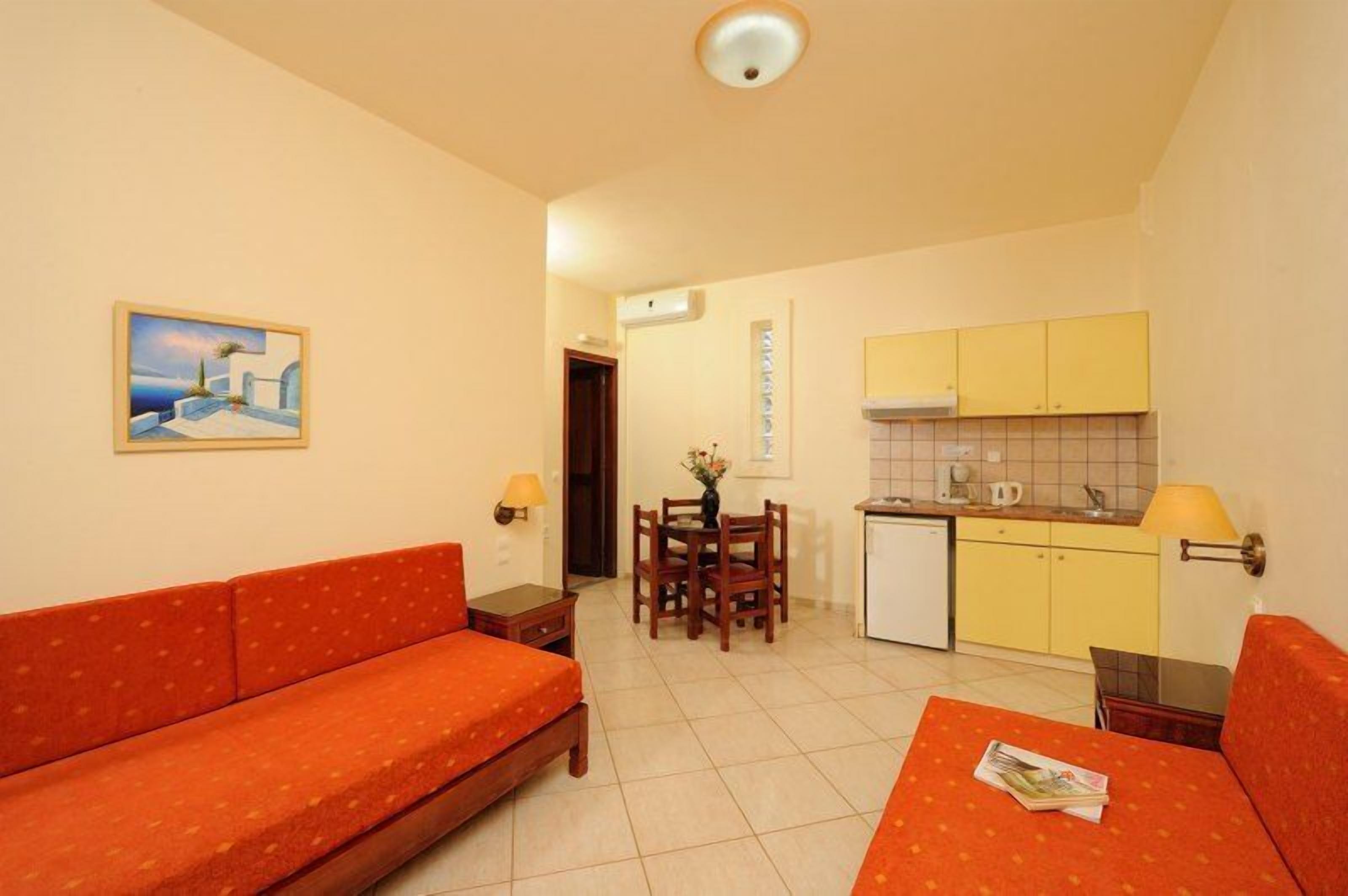 Um espaço compacto com sofá, mesa de jantar e cozinha compacta.