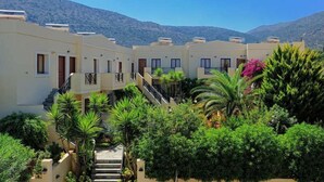 A hotel courtyard with multiple buildings, a central staircase, and lush greenery. - Maria Lambis Apartments (Hersonissos)