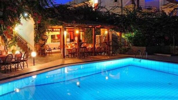 A swimming pool with a covered patio area, outdoor seating, and a staircase leading to the entrance. - Maria Lambis Apartments (Hersonissos)