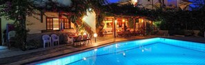 A swimming pool with a covered patio area, outdoor seating, and a staircase leading to the entrance. - Maria Lambis Apartments (Hersonissos)