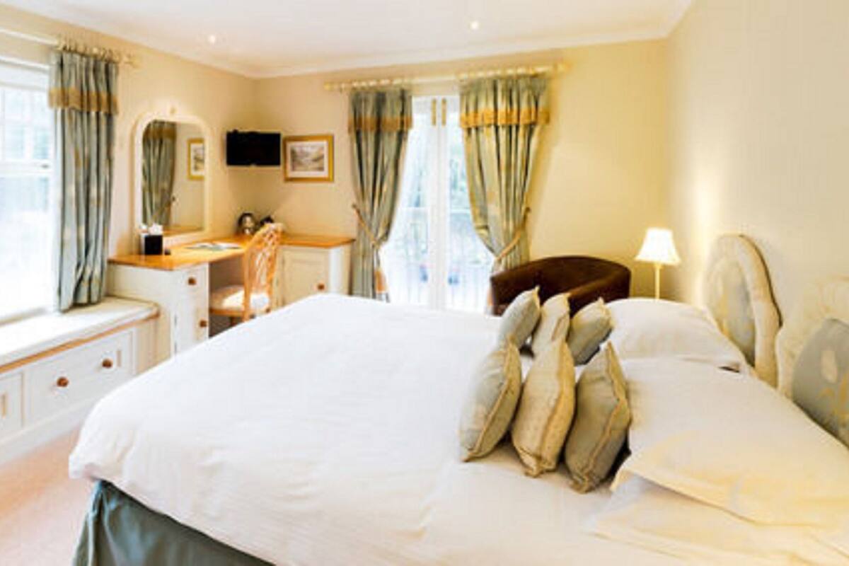 A bedroom with a large bed, a desk, and a chair.