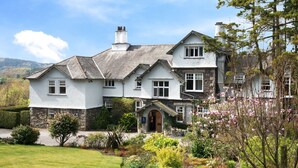 A large, two-story house with a stone facade, multiple windows, and a well-maintained garden. - The Ryebeck Country House & Restaurant (Windermere)