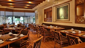 A restaurant with wooden furniture, tables with chess sets, and large windows. - Aryaduta Pekanbaru (Pekanbaru)