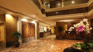 A spacious lobby with a marble floor, a reception desk, and a decorative wall panel. - Aryaduta Pekanbaru (Pekanbaru)