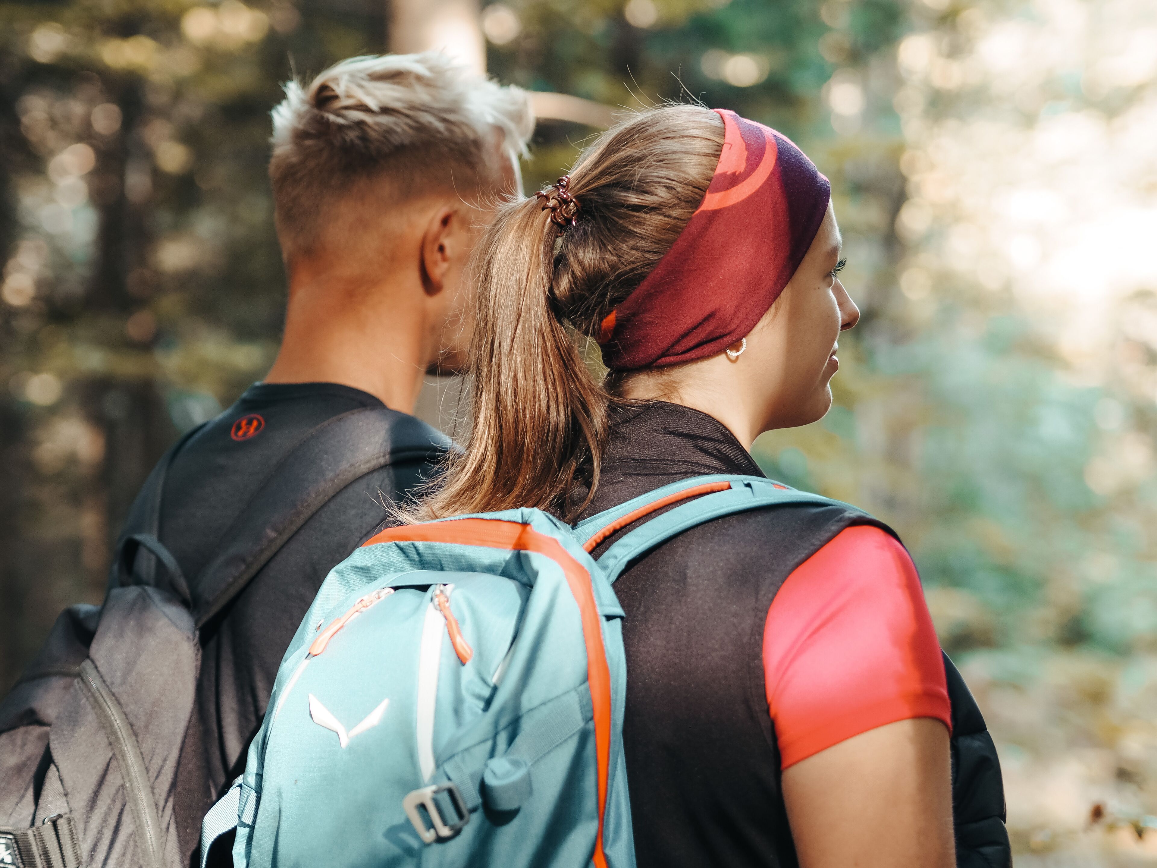 Two people with backpacks in a forested area.
