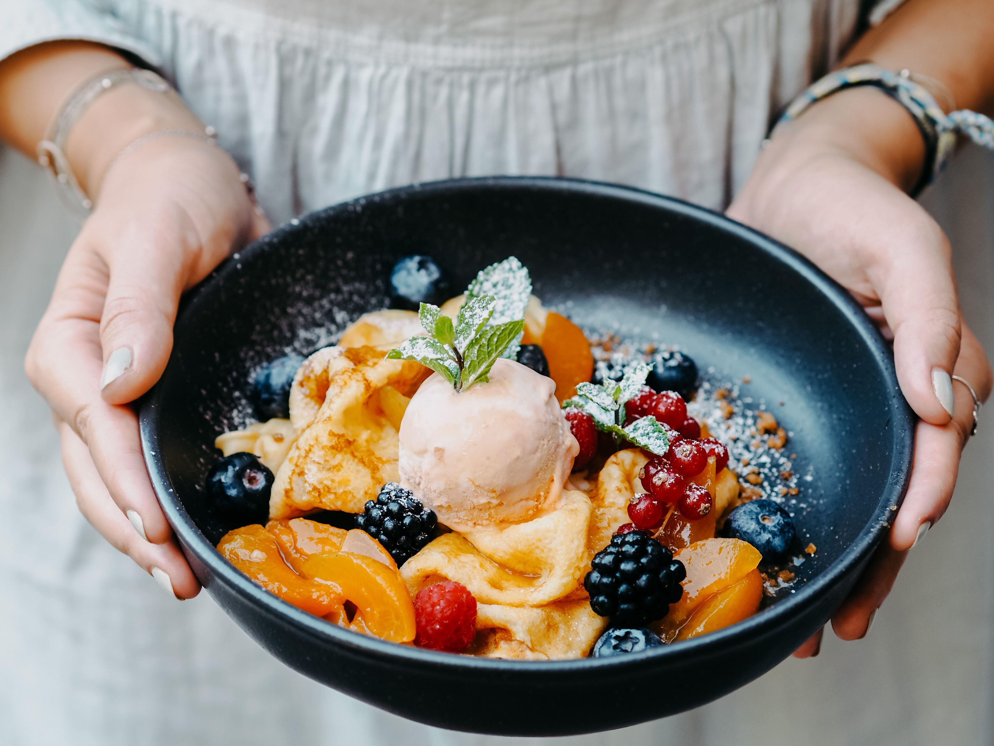 Una ciotola di dessert con frutta e gelato.