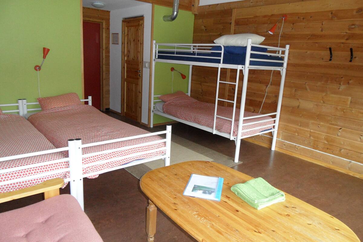 A room with bunk beds, a wooden table, and a door.
