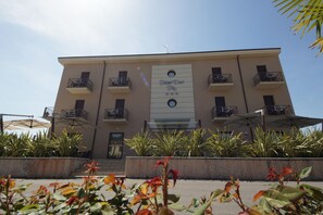 A multi-story hotel with balconies, a central entrance, and a sign reading "Fine Hotel." - Hotel Dori (Peschiera del Garda)