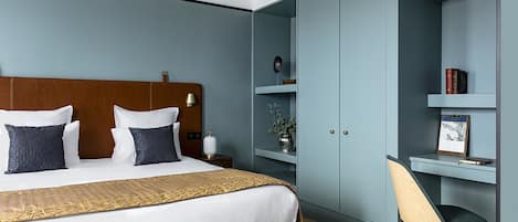 A modern bedroom with a large bed, a desk, and a chair.