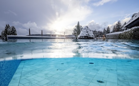 Una piscina techada, una piscina al aire libre, sombrillas. Vier Jahreszeiten am Schluchsee