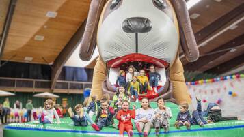Kids can play and interact with a large, friendly dog structure in this lively indoor space.