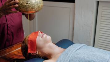 A person lying on a massage table receiving a treatment.
