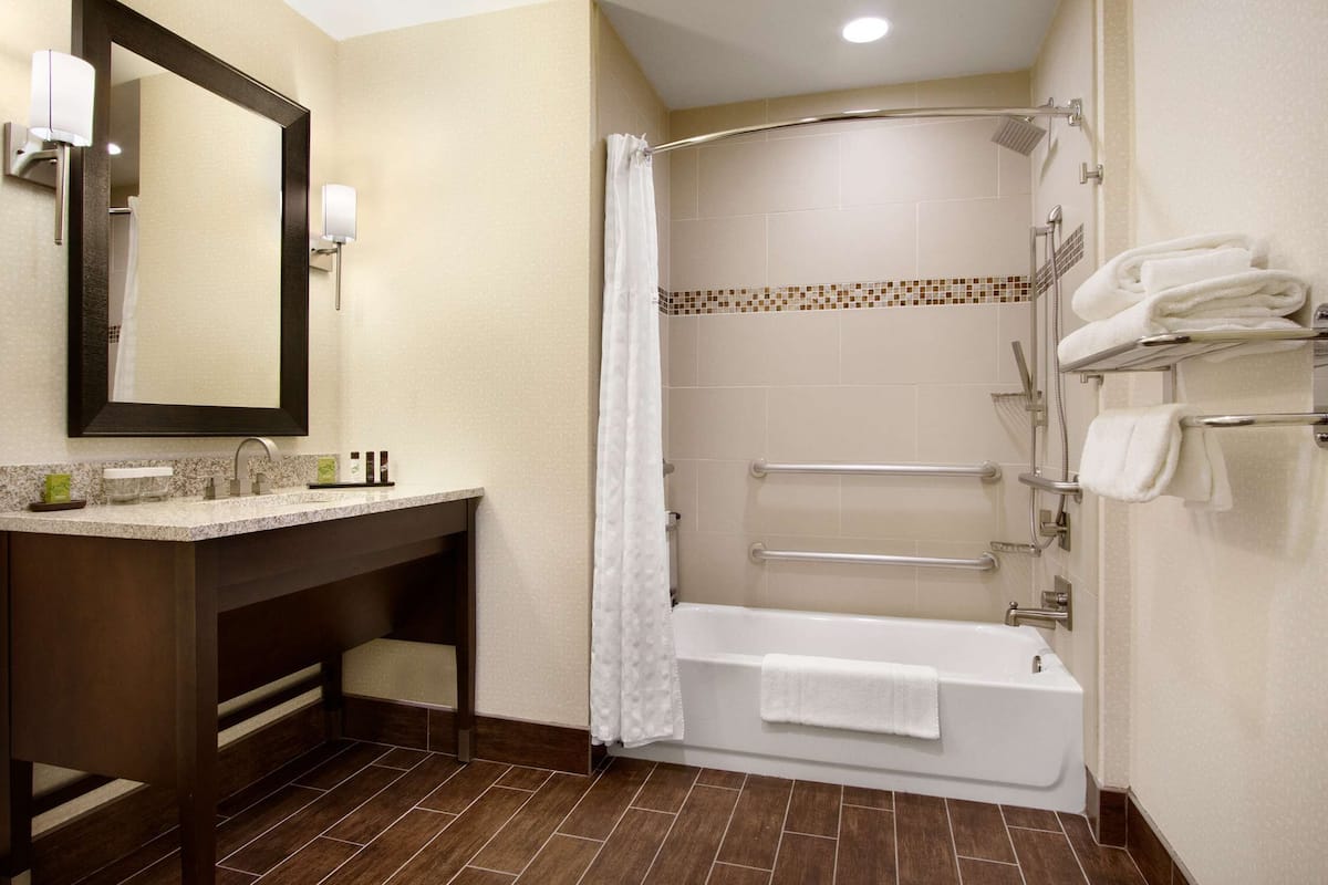 A modern bathroom with a vanity, a bathtub, and a shower.