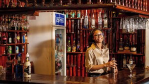 Un coin bar équipé d’un réfrigérateur portant l’inscription « ROYAL » et d’étagères remplies de différentes bouteilles.