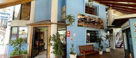 A building with a blue exterior, wooden ceiling, and a sign for Kanuku Tours Eco-Lodge Resort.