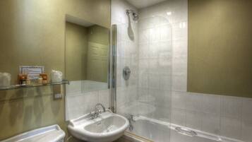 A bathroom with a sink, mirror, shower, and bathtub.