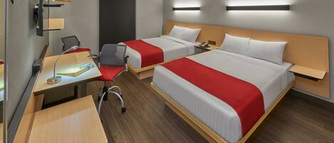 A hotel room with two beds, a desk, a chair, a wardrobe, and a bedside table.