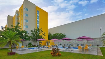 Alberca al aire libre, sombrillas en la alberca y camastros