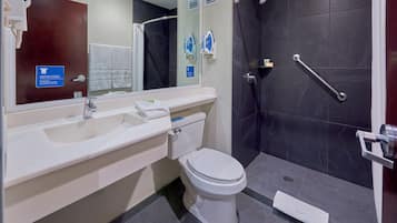 A modern bathroom with a white sink, toilet, and shower area.