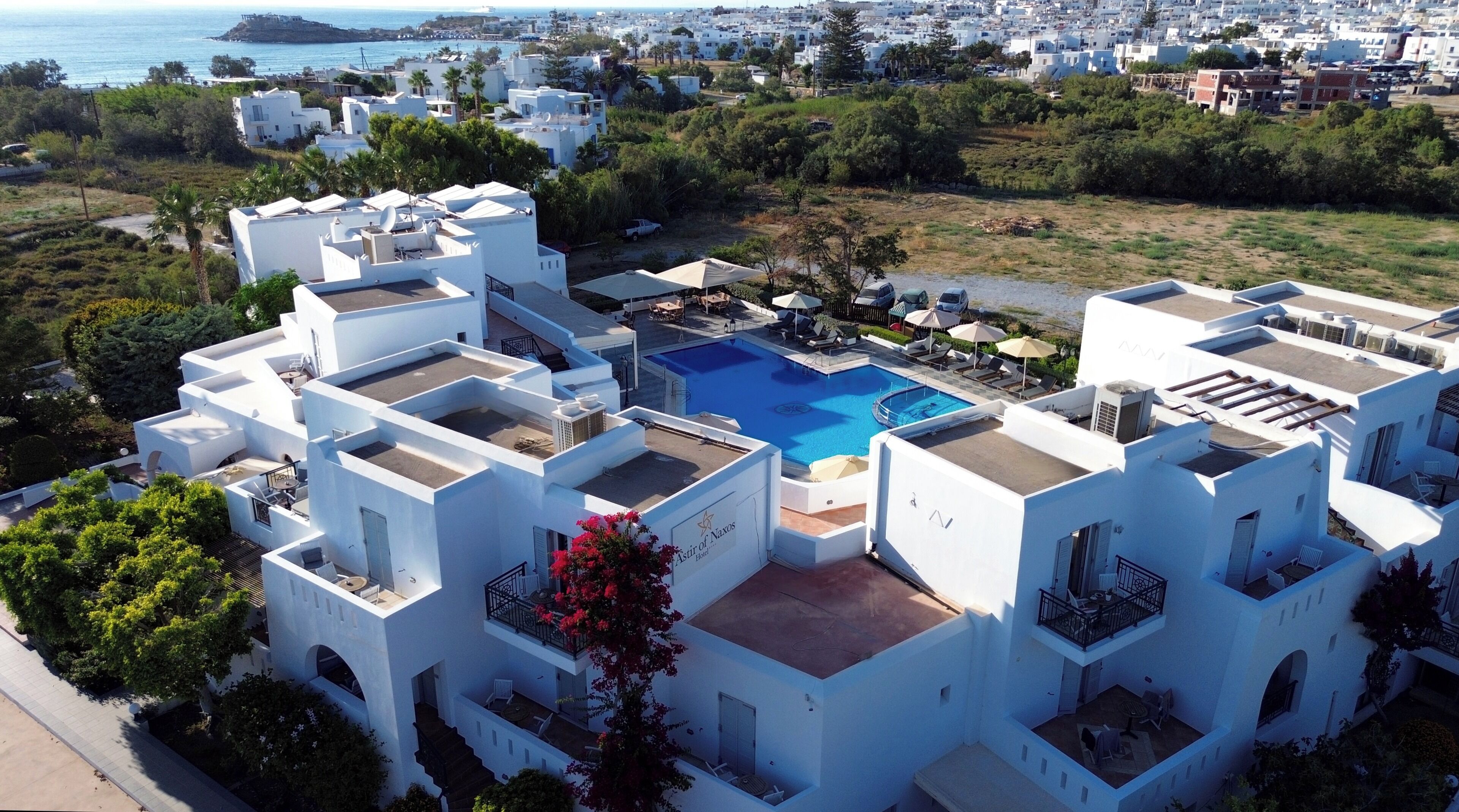 A white building with a rooftop pool and outdoor seating.
