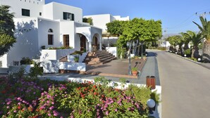 A white building with a central entrance, steps leading up to it, and a paved pathway. - Astir of Naxos (Naxos)