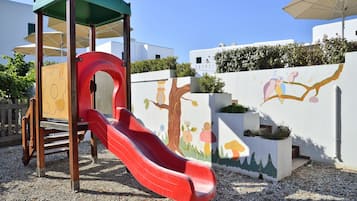 Ein Spielplatz mit einer roten Rutsche und einer Holz-Spielkonstruktion.