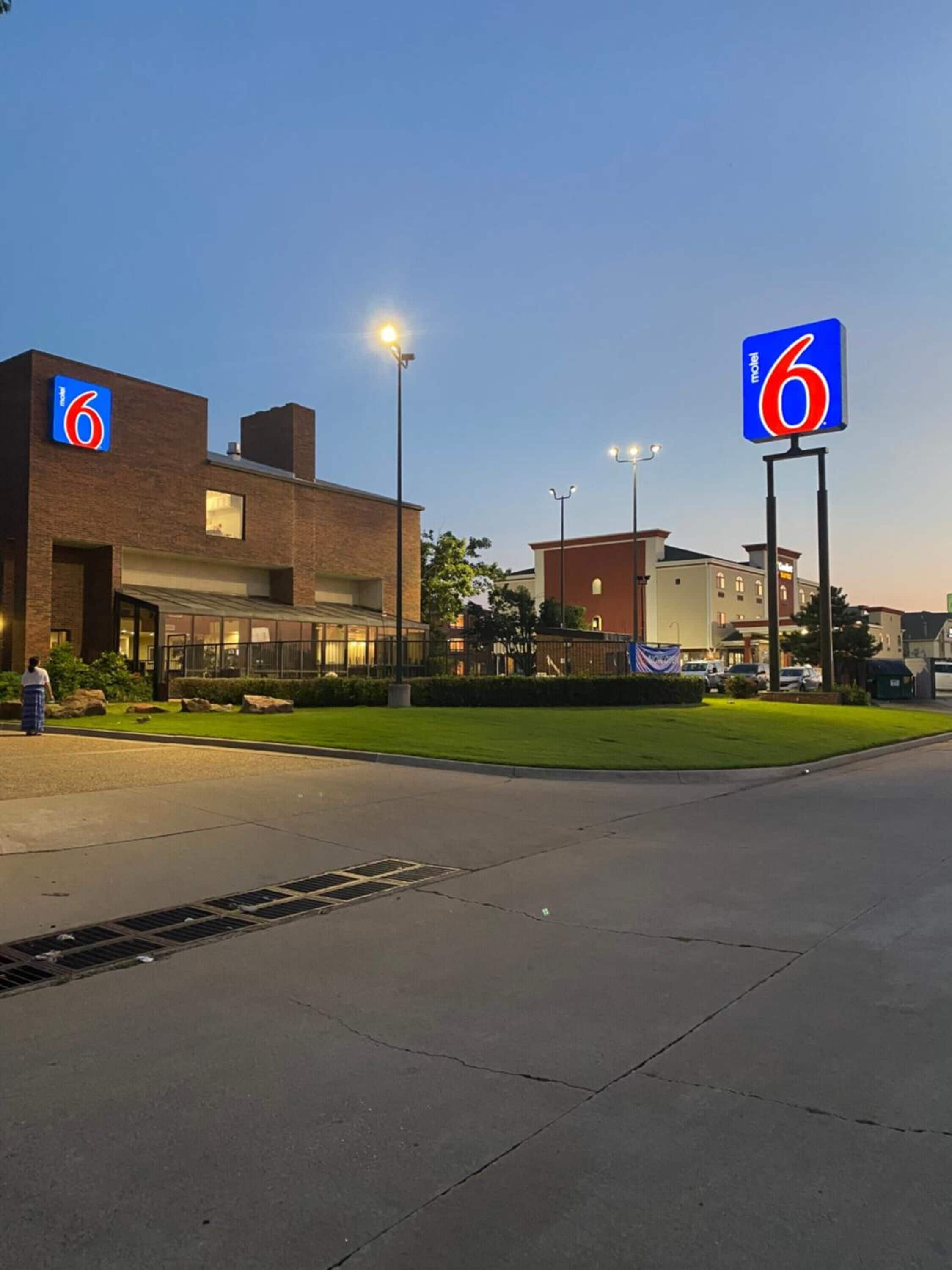 Un motel de six chambres avec une façade en briques, de grandes fenêtres et une pelouse bien entretenue.