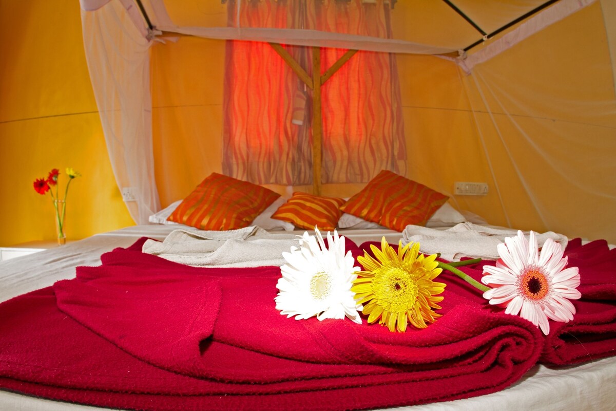 Ein Bett mit roten Handtüchern und drei Blumen.