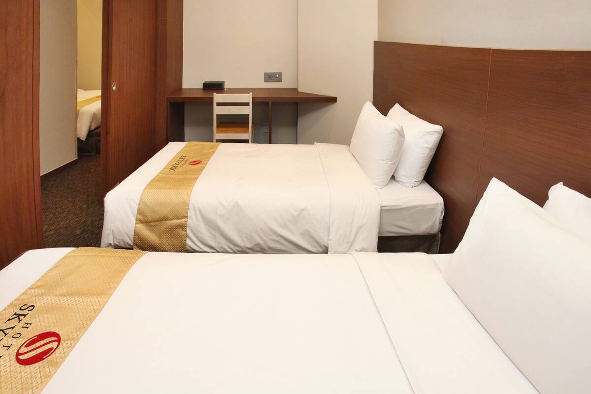A hotel room with a bed, a desk, and a chair.