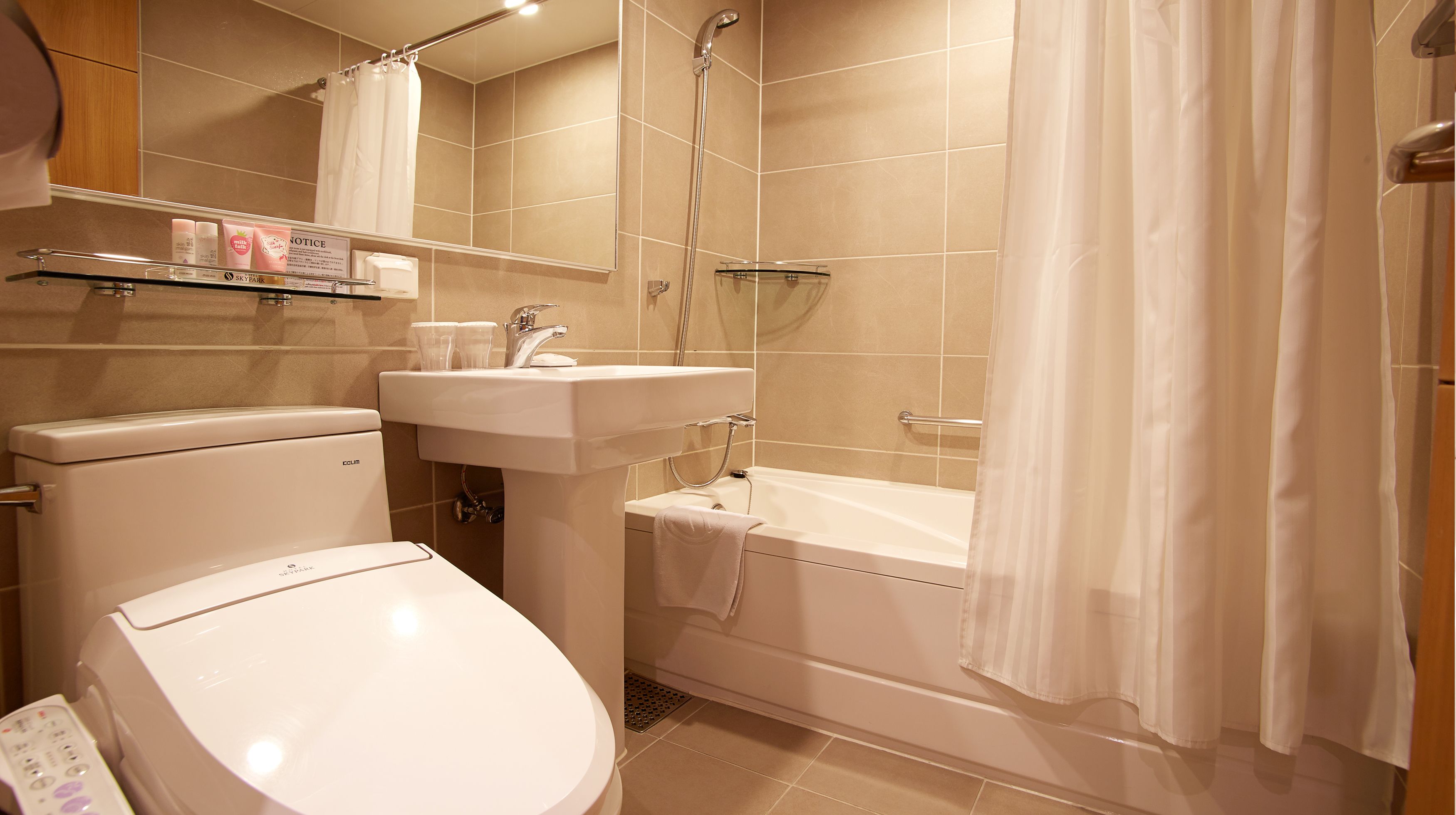 A bathroom with a toilet, sink, bathtub, and shower.