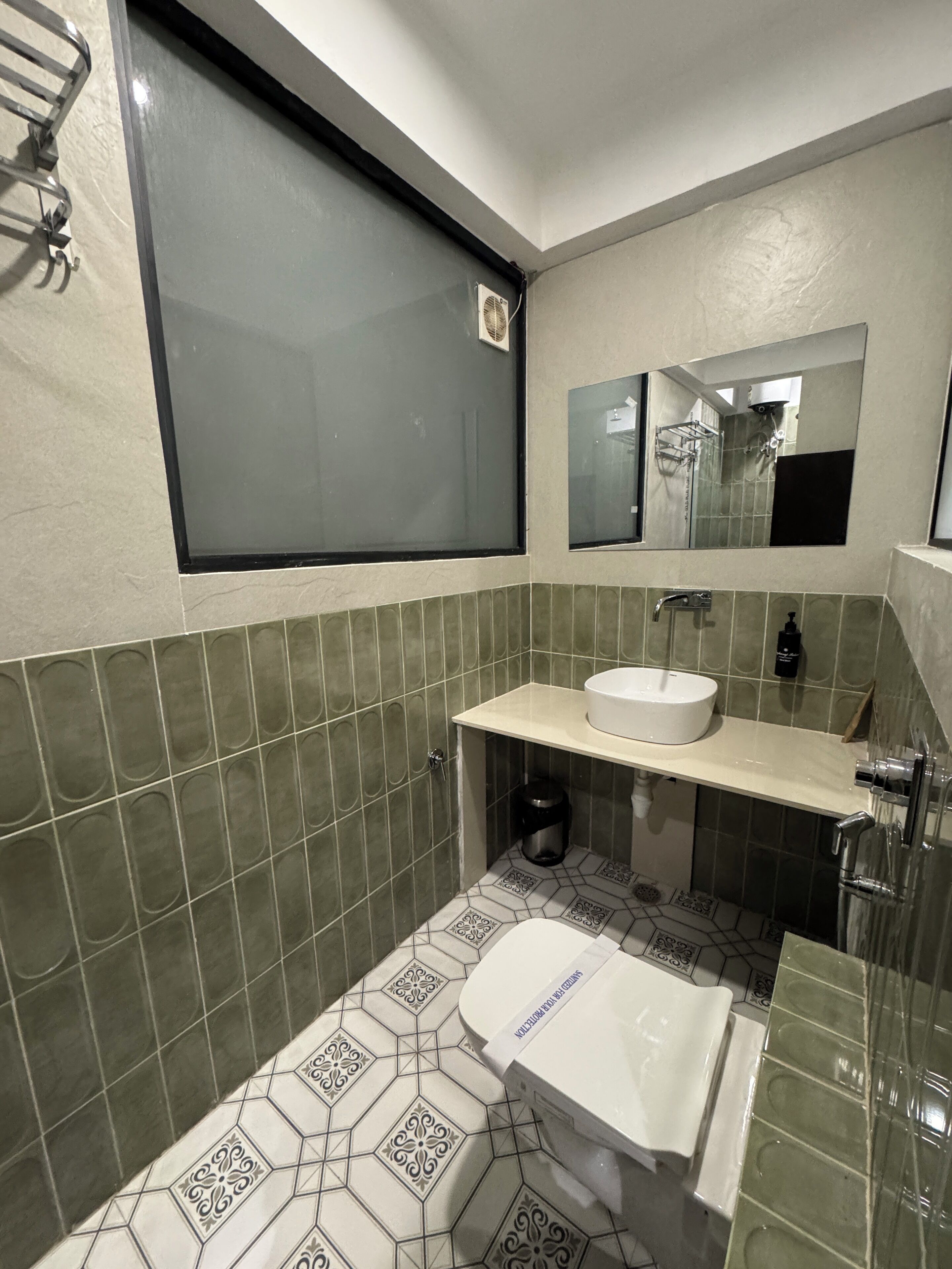 Une salle de bain avec des toilettes, un lavabo et une fenêtre.