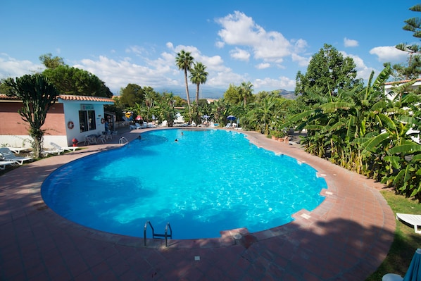 Outdoor pool, open 9:00 AM to 8 PM, pool umbrellas