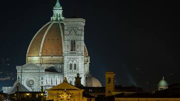 A historic building with a large dome and intricate architectural details, illuminated at night.