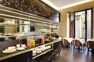A buffet area with various food items, beverages, and a seating area with tables and chairs.