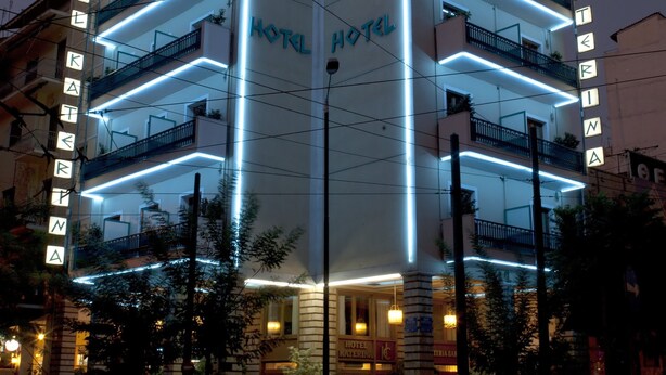 Ein Hotel mit mehreren Balkonen und einer Neonreklame.