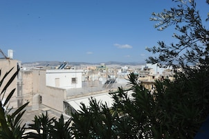 A rooftop view of a cityscape with buildings, satellite dishes, and a clear sky.