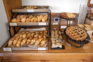 Una vitrina de panadería con diversas opciones de repostería, como croissants, pan y tartas.