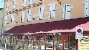 A building with a sign reading "Salon de la Poste" and a restaurant sign below. - Hotel de La Poste (Clamecy)