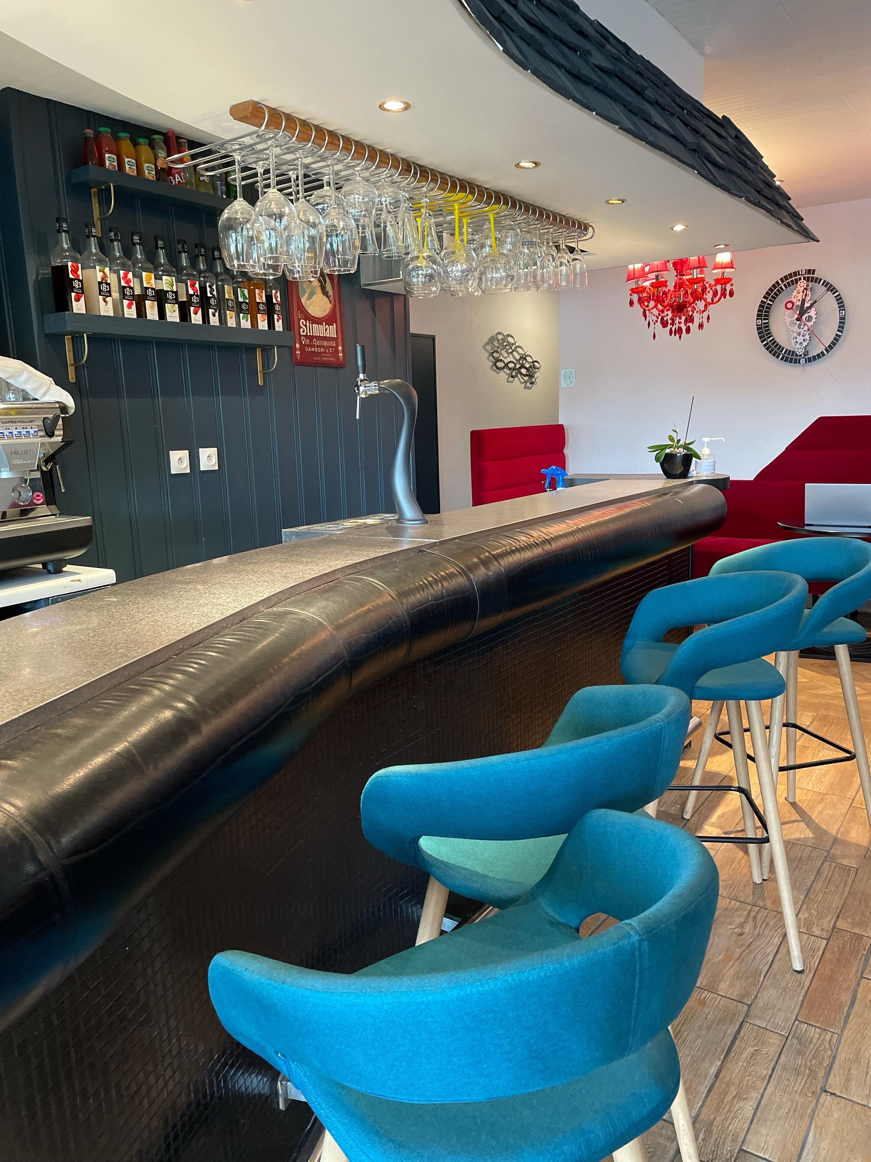 Un espace bar avec un comptoir, des tabourets et un assortiment de bouteilles.